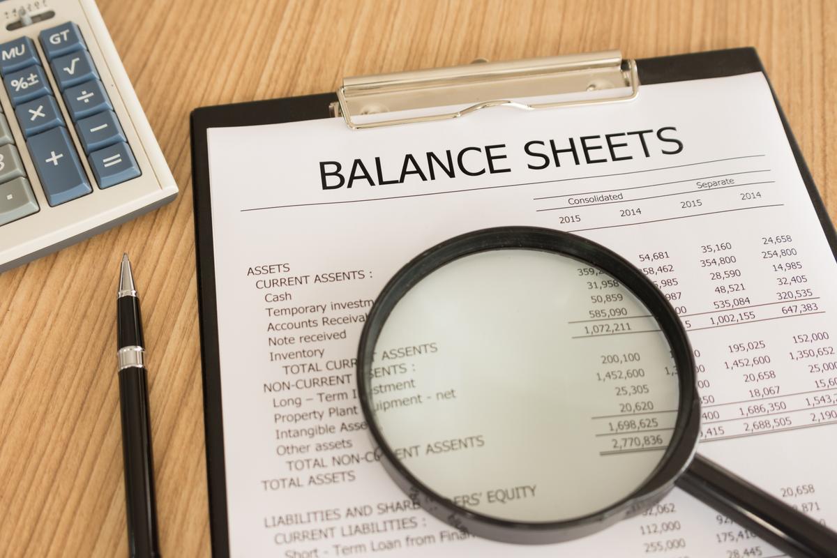 "Bookkeeper preparing a balance sheet with financial documents and a calculator, following 7 powerful steps